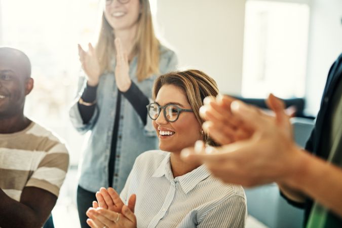 Group,Of,Diverse,Businesspeople,Smiling,And,Clapping,During,A,Meeting